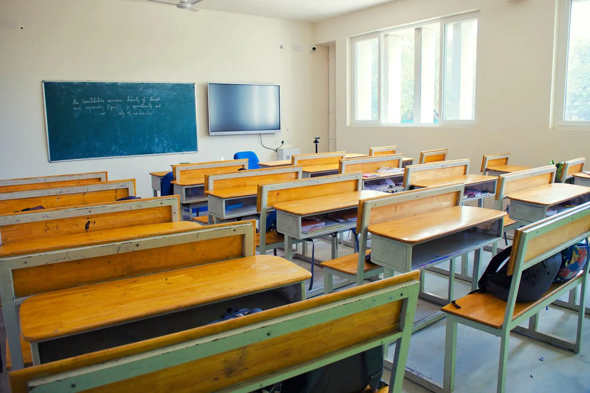 A bright classroom with rows of wooden desks
